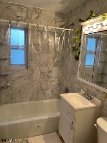 a bathroom with a sink and mirror with bathtub