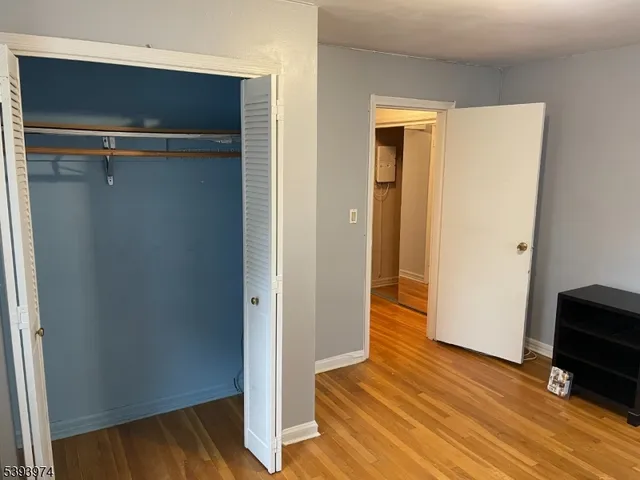 a view of a hallway with wooden floor and closet