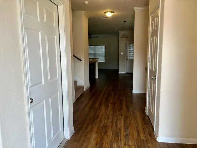 a view of a hallway with wooden floor and staircase