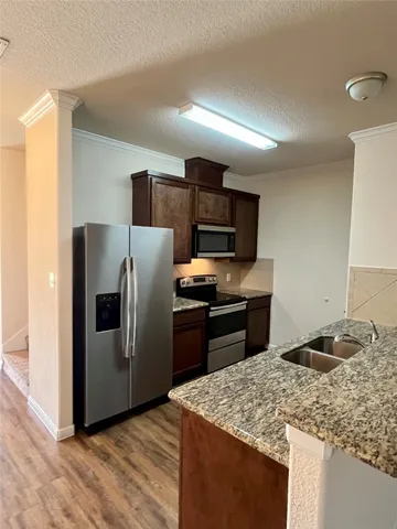 a kitchen with stainless steel appliances granite countertop a refrigerator stove and sink