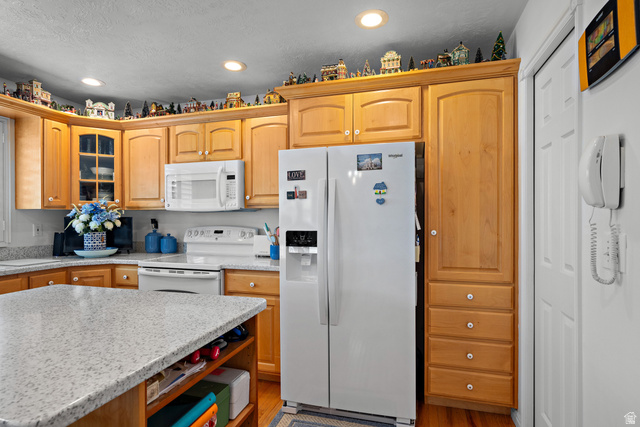 166 South Ridgeview Drive Orem, UT 84058 - Photo 12 of 38 Wood-finish cabinetry, recessed lighting, white side-by-side refrigerator, white built-in microwave, and wood-finish flooring