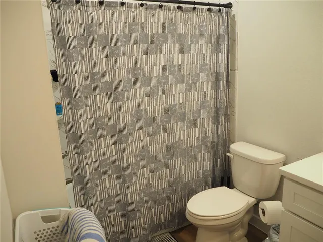 a white toilet sitting next to a shower curtain