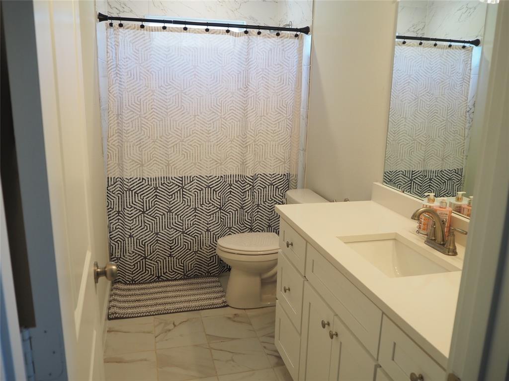 1220 Elva Warren Street Fort Worth, TX 76115 - Photo 19 of 23 a bathroom with a sink a toilet and shower