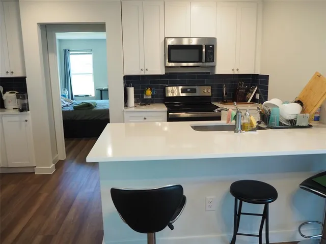 a kitchen with stainless steel appliances a stove a microwave a sink and cabinets