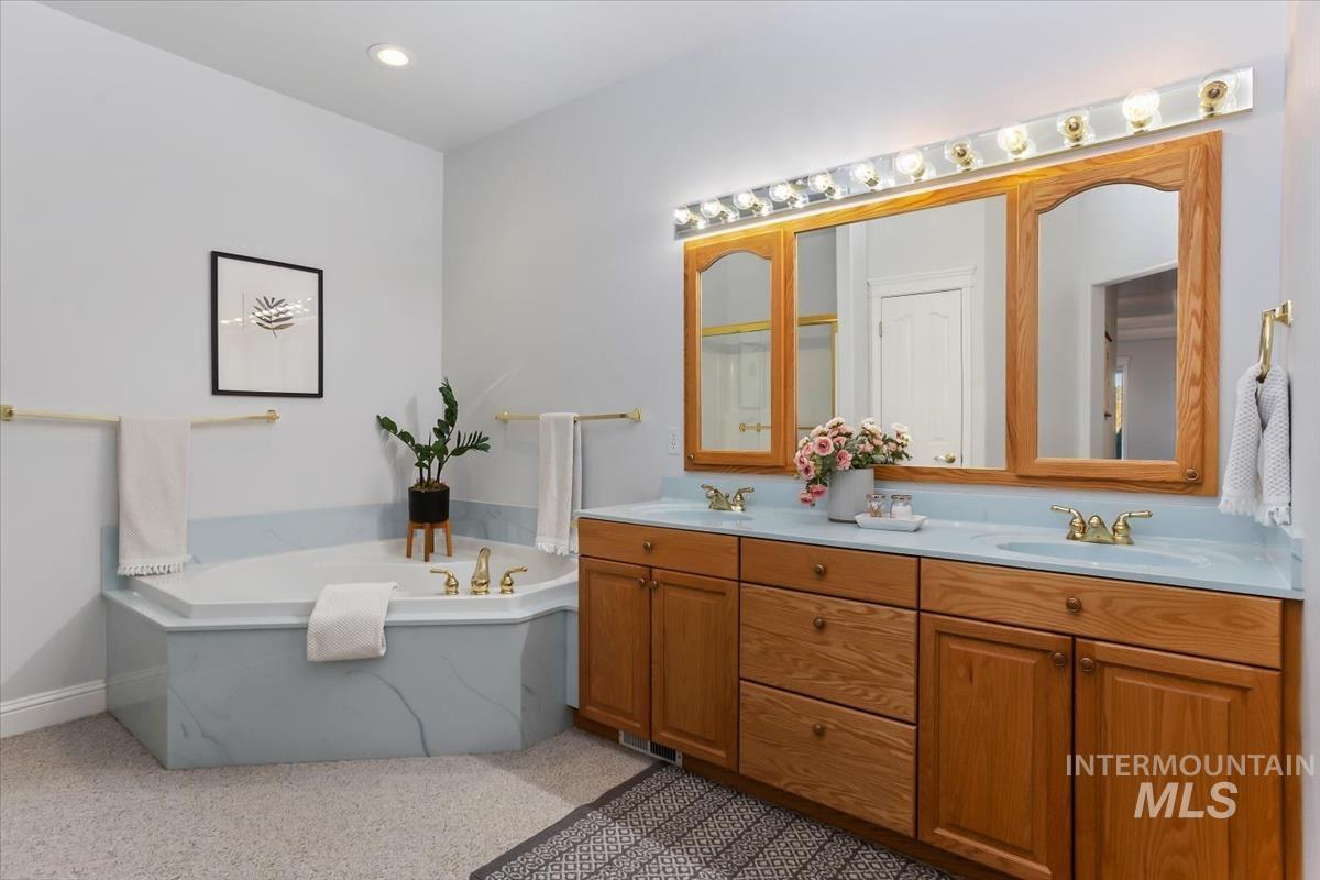 25074 The Driving Lane Caldwell, ID 83607 - Photo 17 of 32 Full bath with double vanity, a garden tub, and recessed lighting