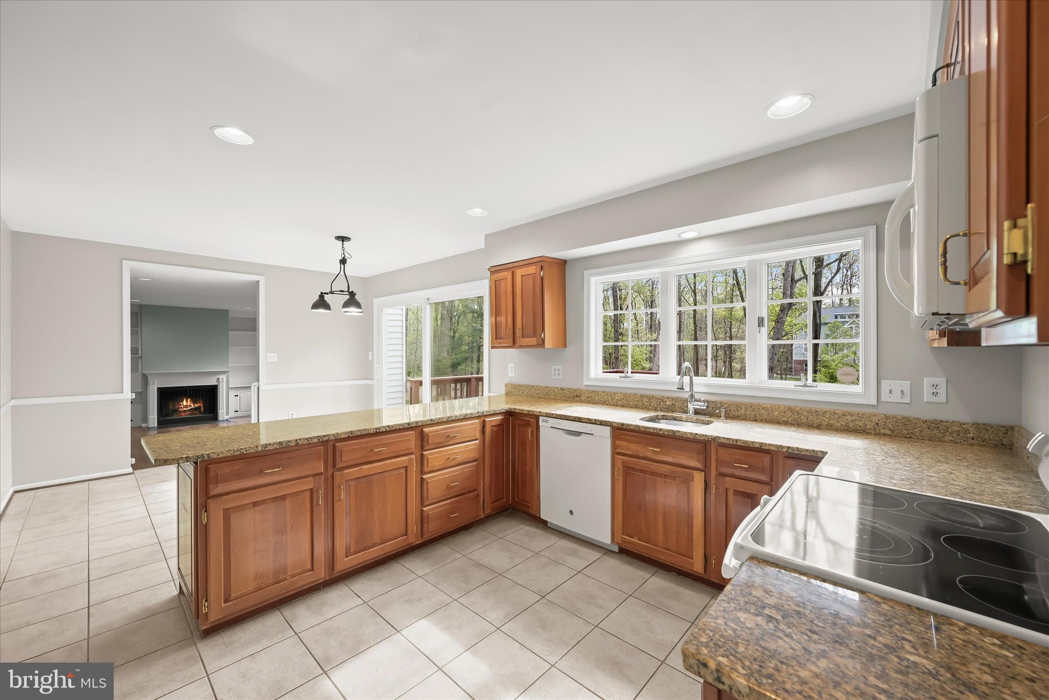 10428 Schoolmaster Place Columbia, MD 21044 - Photo 22 of 69 a large kitchen with kitchen island granite countertop a sink and dishwasher a stove with wooden cabinets