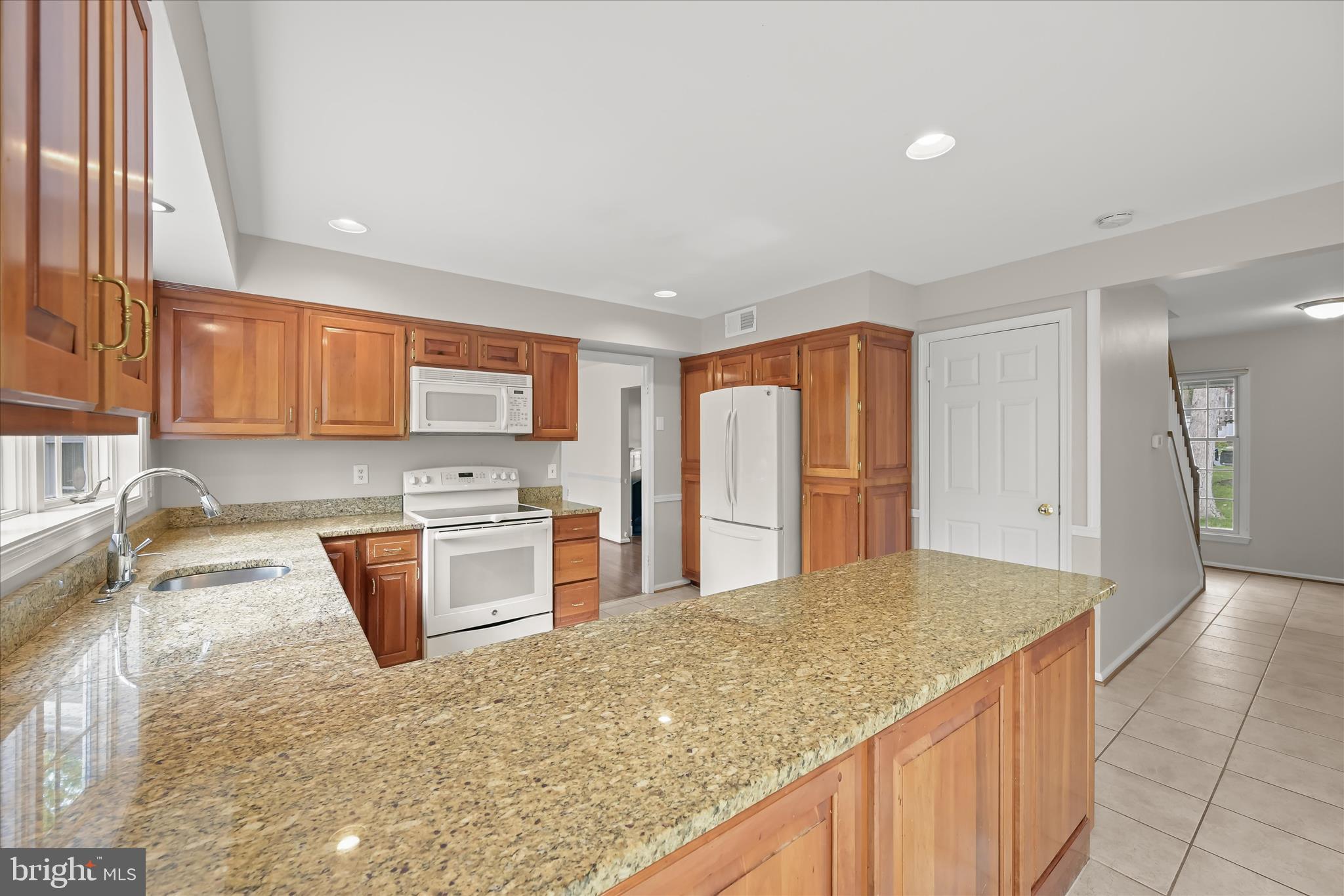 10428 Schoolmaster Place Columbia, MD 21044 - Photo 23 of 69 a kitchen with stainless steel appliances granite countertop a sink stove and refrigerator