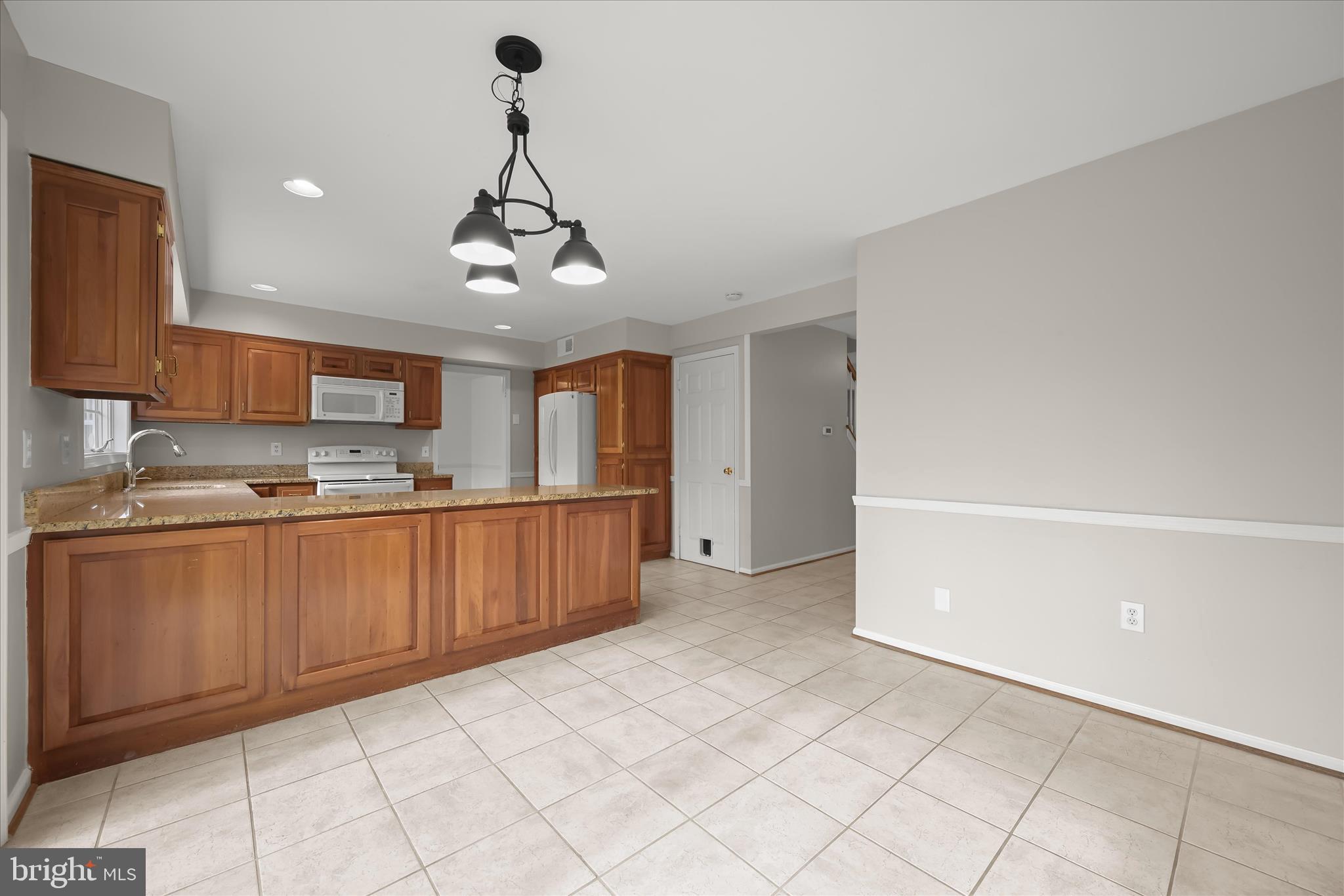 10428 Schoolmaster Place Columbia, MD 21044 - Photo 28 of 69 a kitchen with stainless steel appliances granite countertop a refrigerator a sink dishwasher and white cabinets with granite countertops