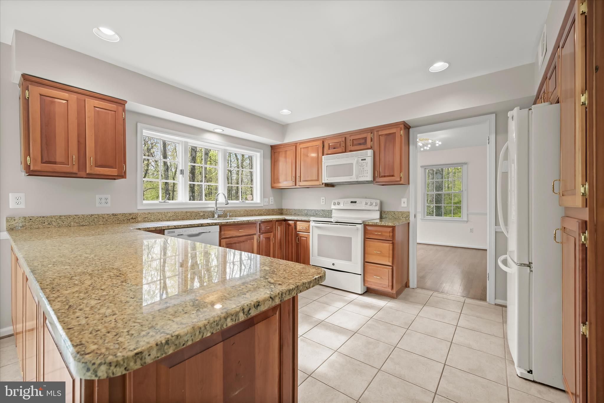 10428 Schoolmaster Place Columbia, MD 21044 - Photo 7 of 69 a kitchen with stainless steel appliances granite countertop a stove a sink and a microwave