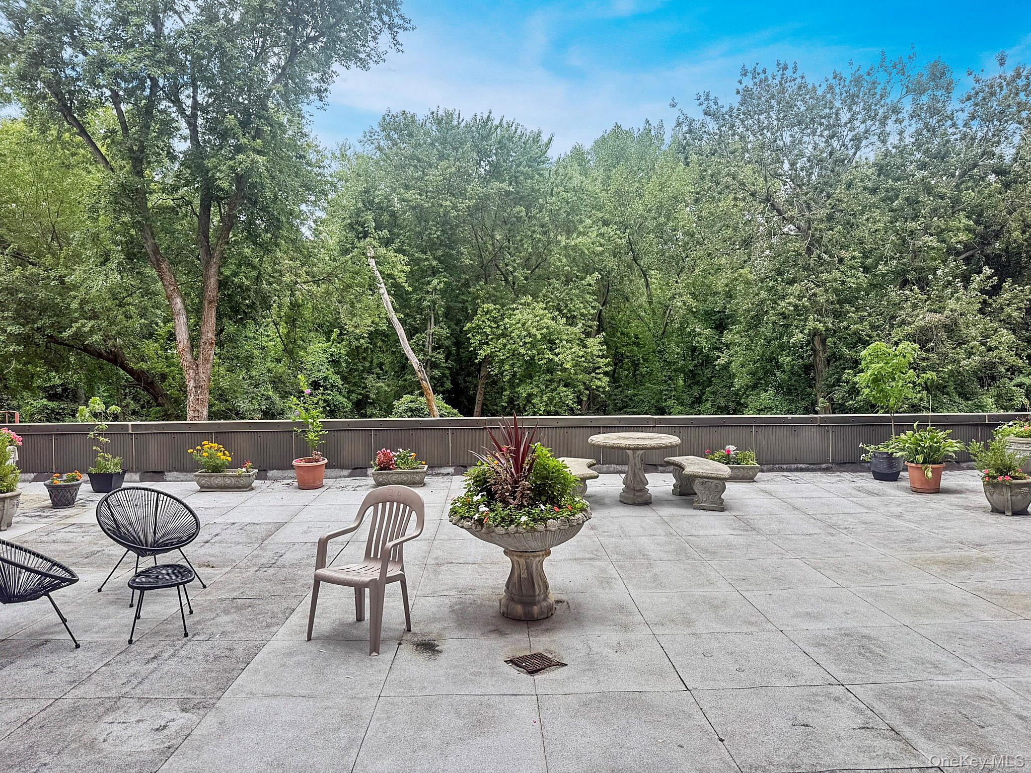 1111 Midland Avenue, Unit 5J Bronxville, NY 10708 - Photo 12 of 13 View of patio featuring a wooded view
