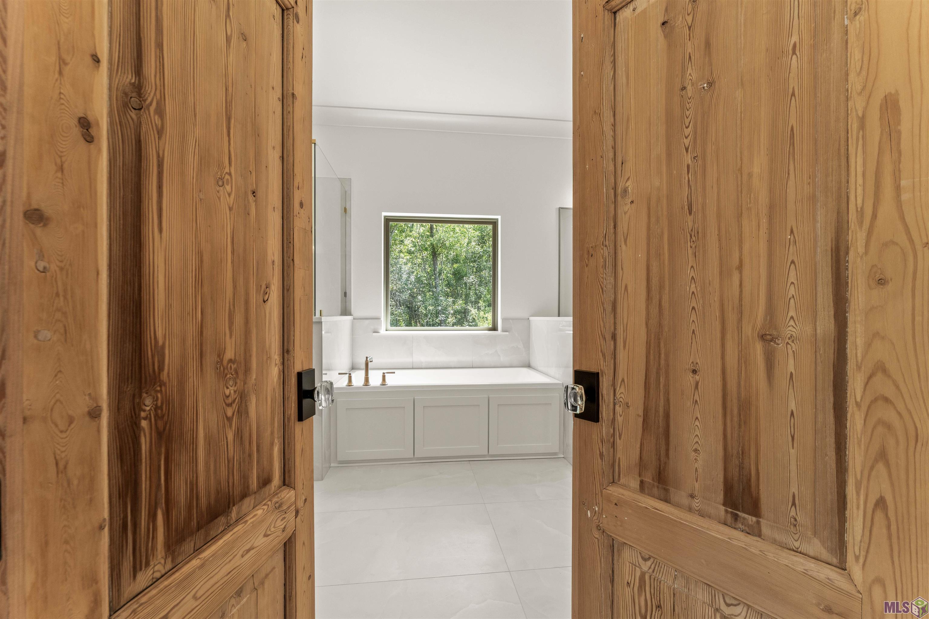 9189 Hillon Hood Road Denham Springs, LA 70726 - Photo 20 of 41 Antique Reclaimed Wood Doors from NOLA entering Primary Bath Spa