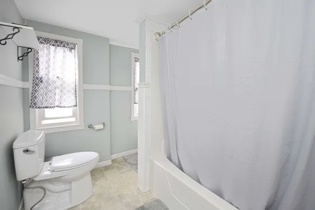 a bathroom with a toilet and a shower