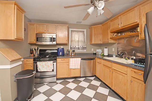 a kitchen with stainless steel appliances a sink stove refrigerator granite counter tops and cabinets