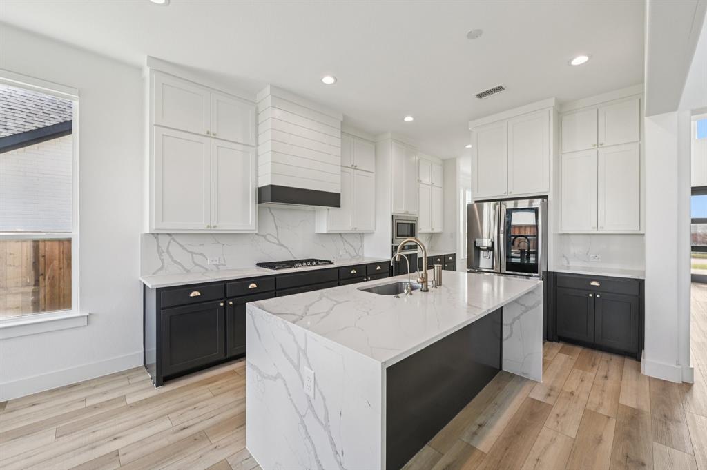 a large kitchen with stainless steel appliances granite countertop a sink stove and refrigerator