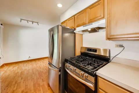 a kitchen with stainless steel appliances granite countertop a refrigerator and a stove top oven