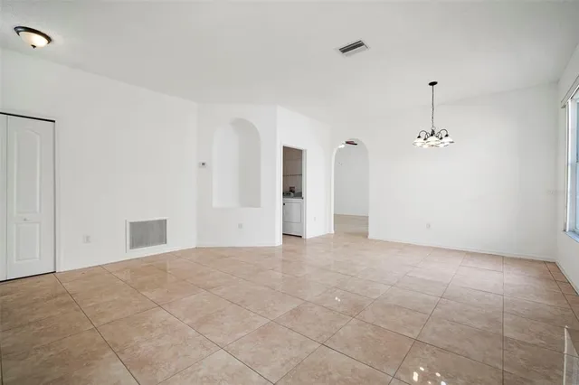 an empty room with entrance and windows