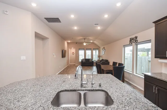 a kitchen with stainless steel appliances granite countertop a sink stove and refrigerator