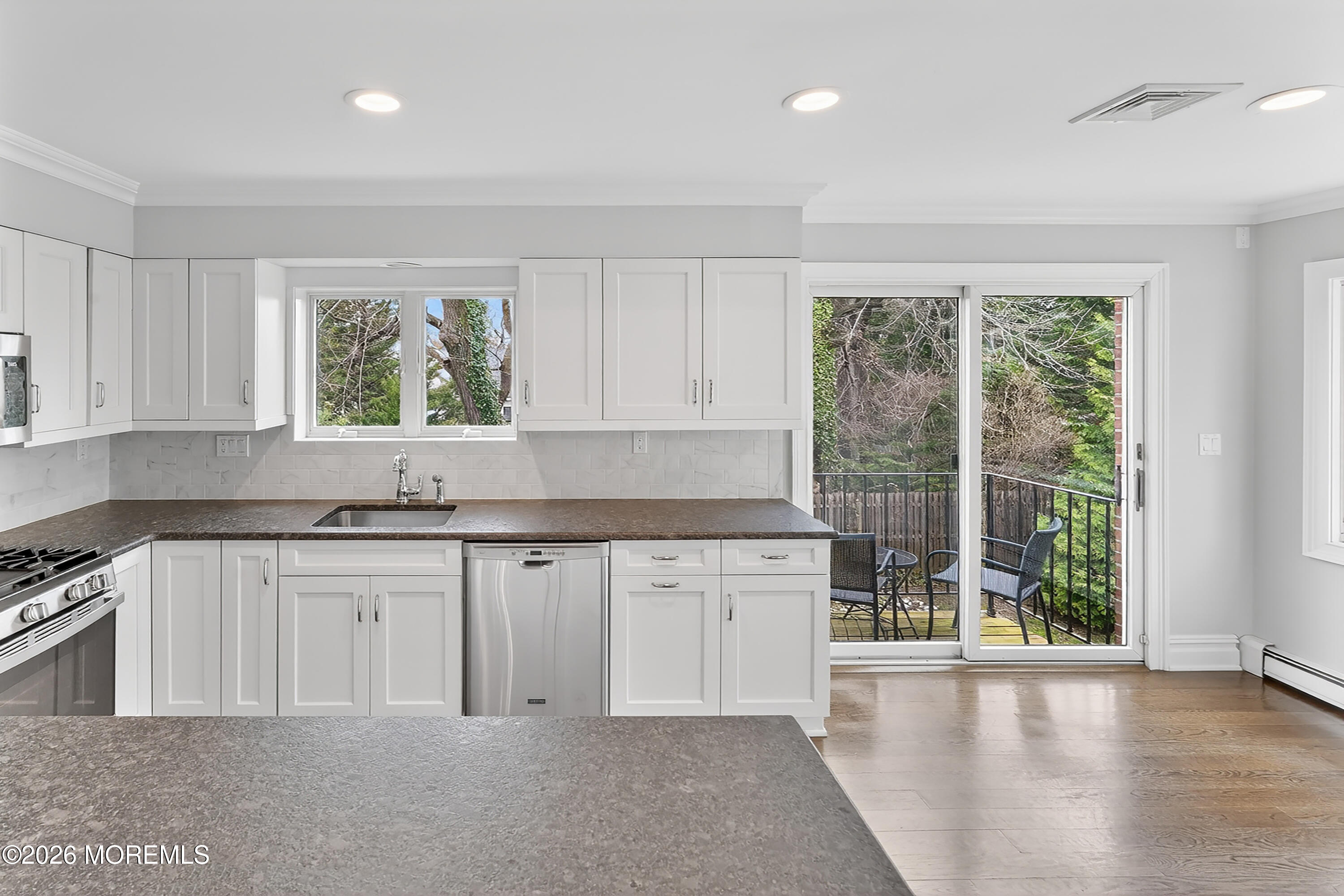 65 East River Road, Unit 20 Rumson, NJ 07760 - Photo 5 of 37 a kitchen with granite countertop a stove a sink and white cabinets with wooden floor