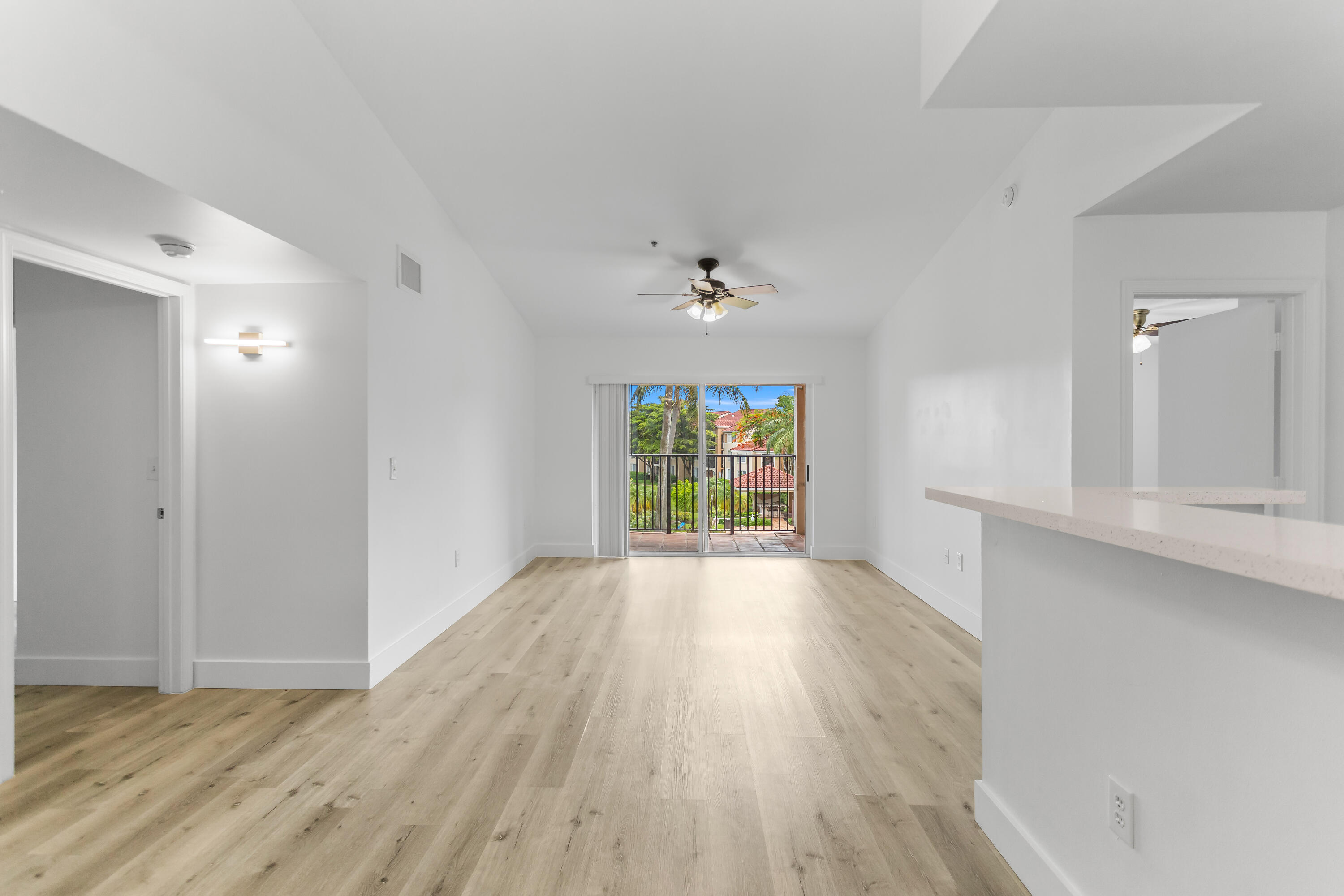 2113 Renaissance Boulevard, Unit 306 Miramar, FL 33025 - Photo 3 of 59 a view of an empty room with wooden floor and a window