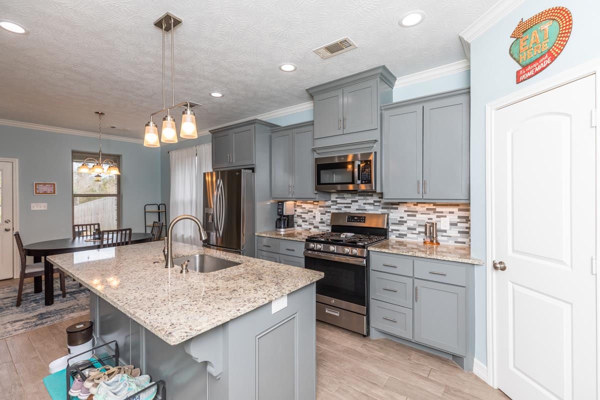 314 Long Leaf Street Silsbee, TX 77656 - Photo 10 of 31 a kitchen with kitchen island granite countertop a sink appliances and cabinets