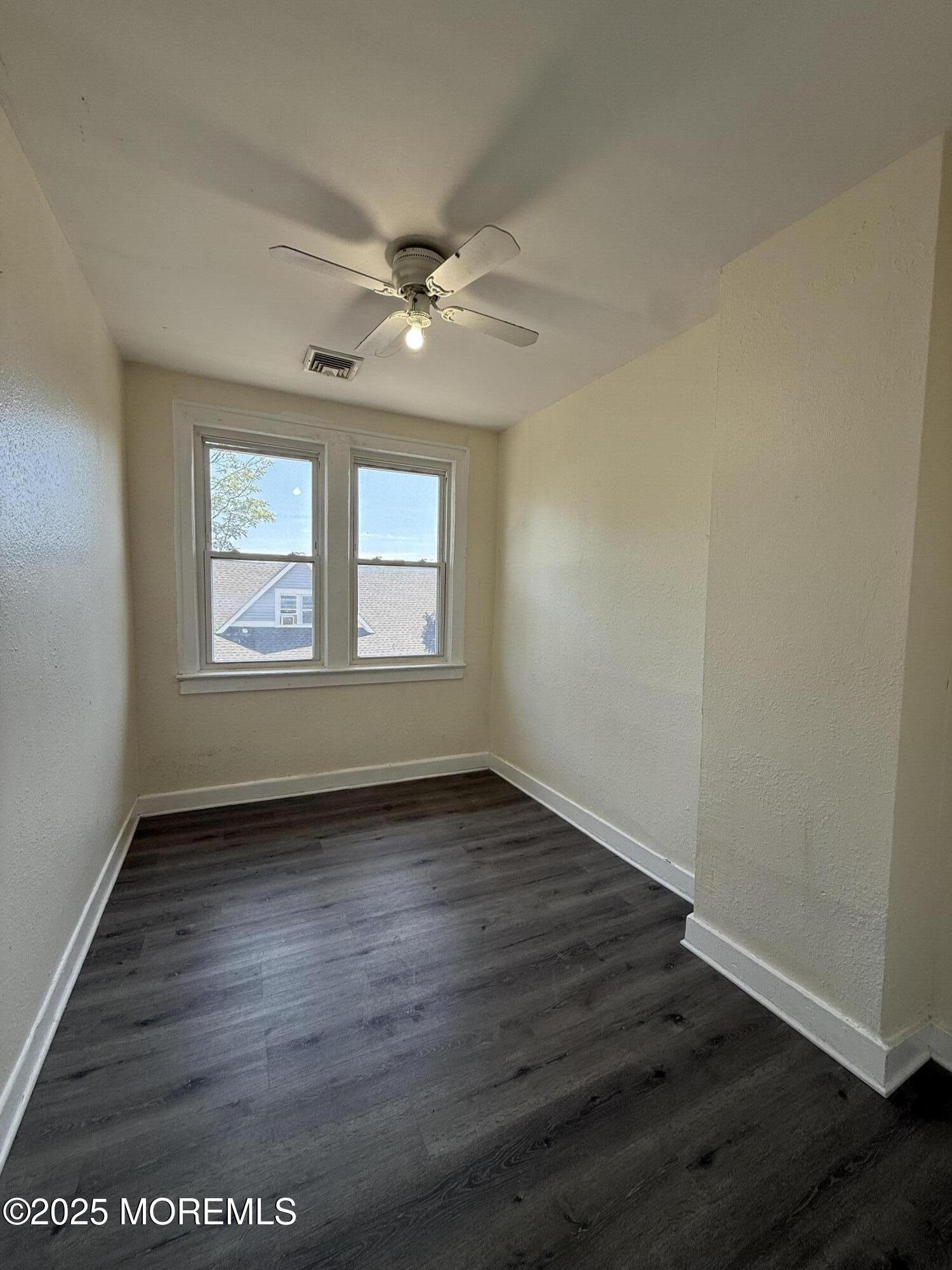 37 2nd Avenue, Unit 5 Long Branch, NJ 07740 - Photo 2 of 5 a view of an empty room with wooden floor and a window