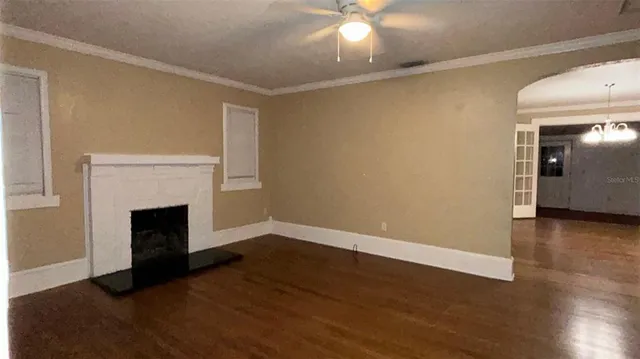 a view of empty room with wooden floor and fireplace