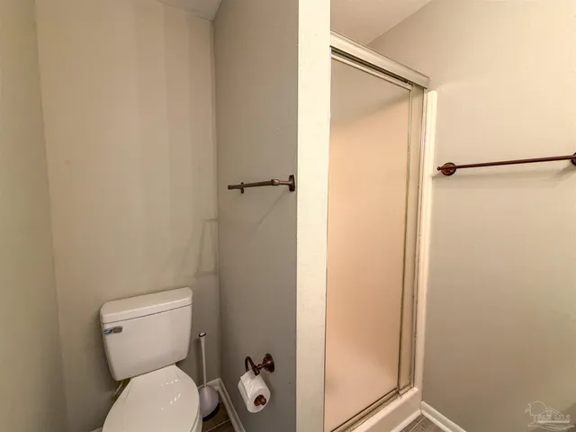 a white toilet sitting next to a shower
