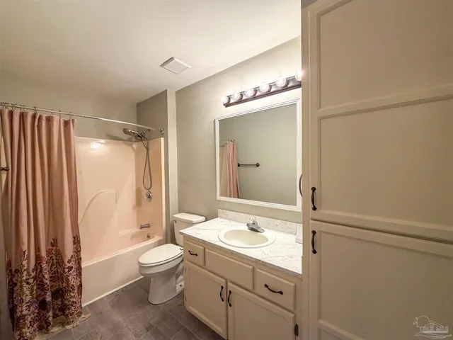 a bathroom with a granite countertop sink toilet a mirror a vanity and shower