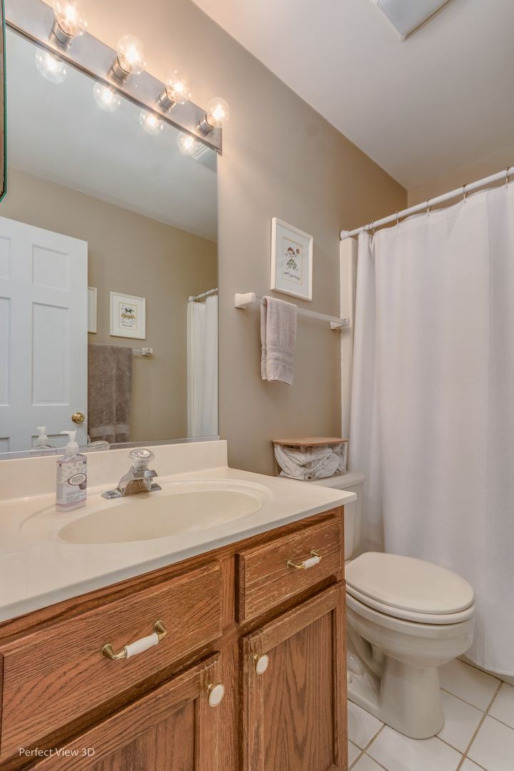 705 Churchill Lane Oswego, IL 60543 - Photo 22 of 34 a bathroom with a sink a toilet a mirror and shower