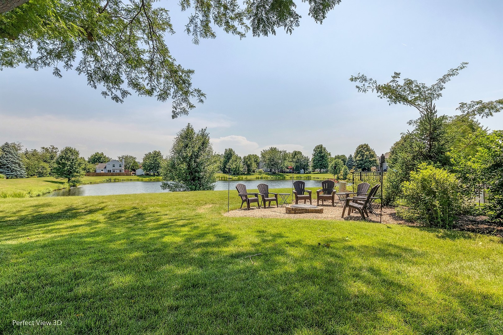 705 Churchill Lane Oswego, IL 60543 - Photo 32 of 34 a view of a lake with lawn chairs and large trees