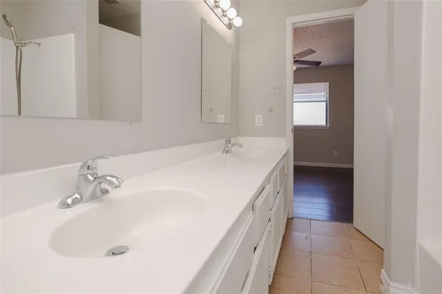 a en suite bathroom with a sink and a large mirror