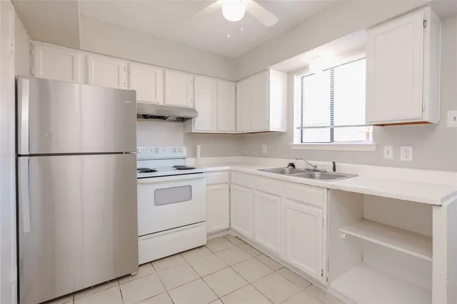 a kitchen with a refrigerator sink and cabinets