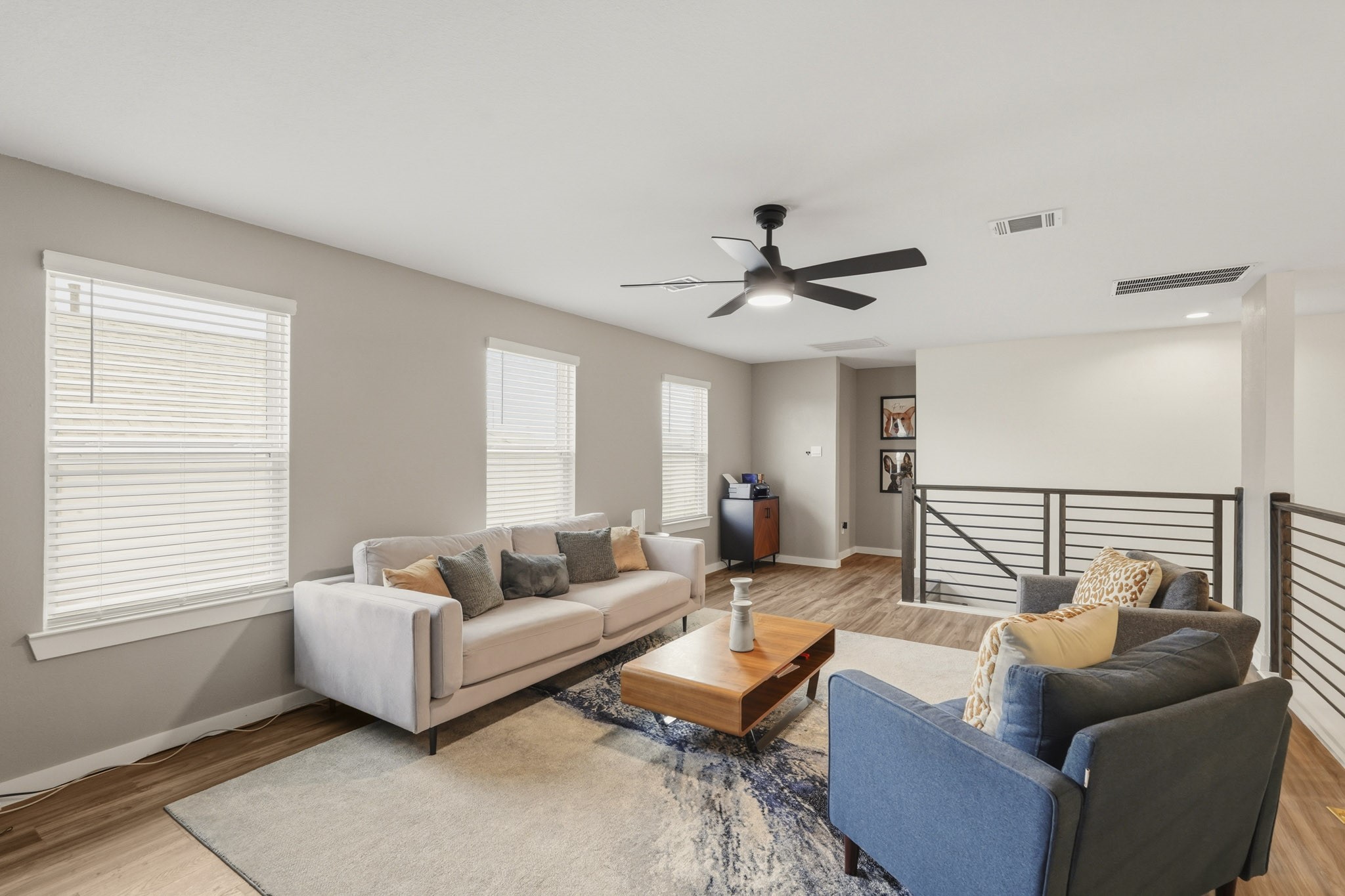 22522 Modica Rift Lane Katy, TX 77449 - Photo 26 of 38 The loft continues to impress from every angle. Bathed in natural light from a wall of windows, with a sleek modern ceiling fan overhead and warm hardwood-style flooring underfoot, this space is as functional as it is comfortable. Whether styled as a second living room, teen hangout, or creative studio, this room gives every member of the household a space to call their own — right upstairs and perfectly connected.