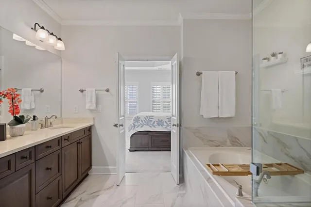 a spacious bathroom with a tub sink and mirror