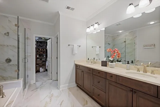 a spacious bathroom with double vanity a sink a mirror and a shower