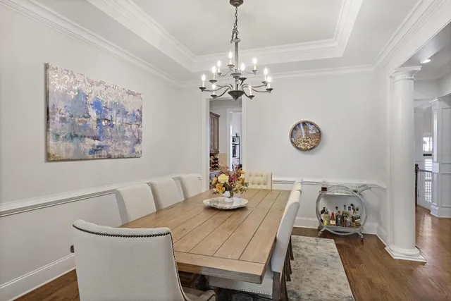 a view of a dining room with furniture a chandelier and wooden floor