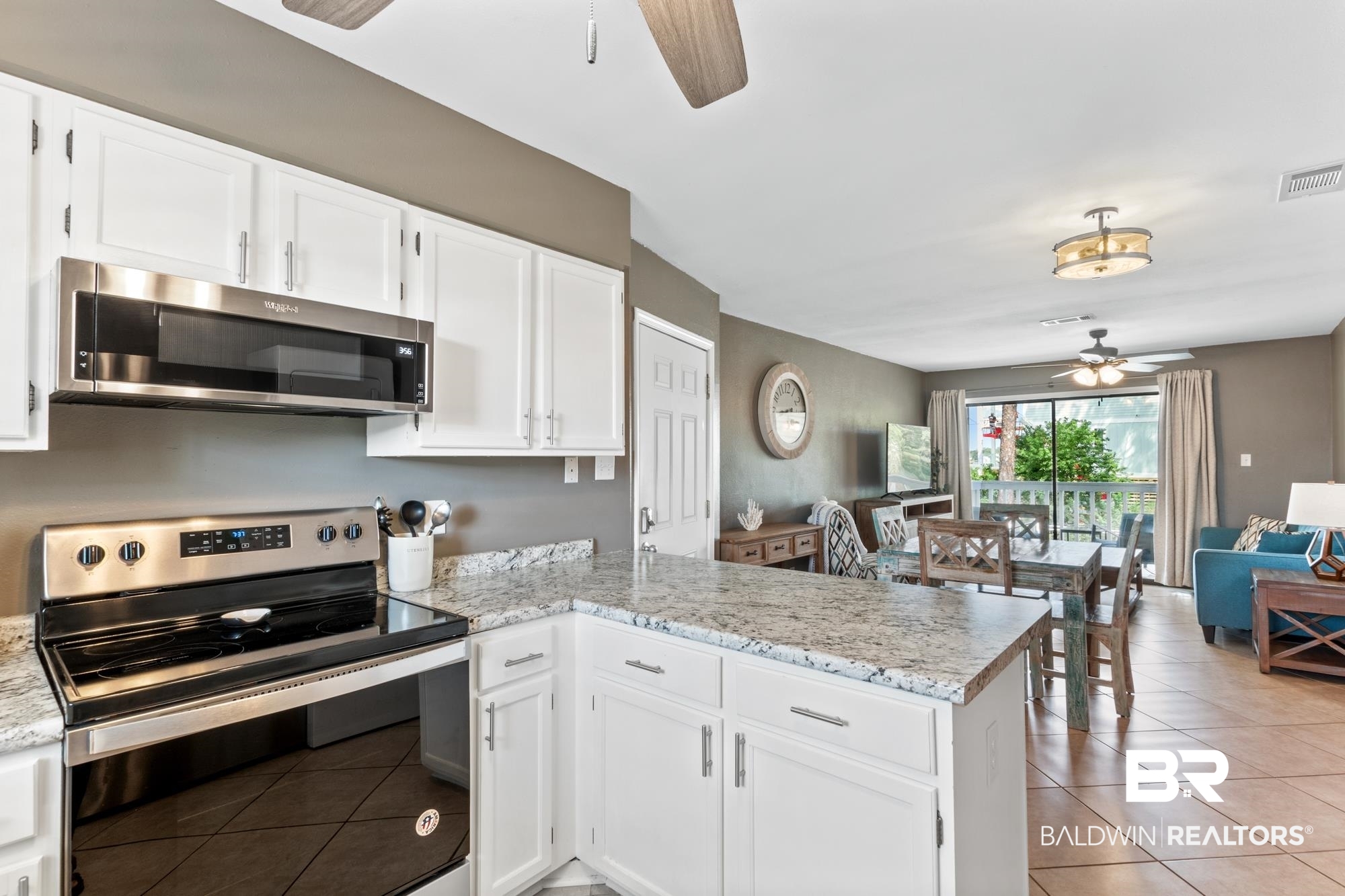 25925 -C Canal Road, Unit 203 Orange Beach, AL 36561 - Photo 9 of 57 Kitchen with white cabinetry, stainless steel appliances, kitchen peninsula, ceiling fan, and light tile patterned flooring