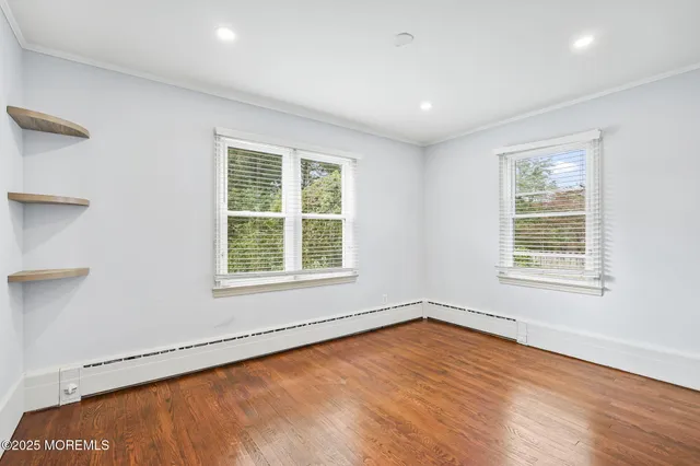 a view of an empty room with wooden floor and closet