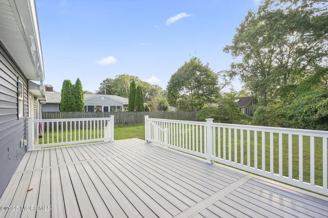 a front view of house with yard and trees in the background