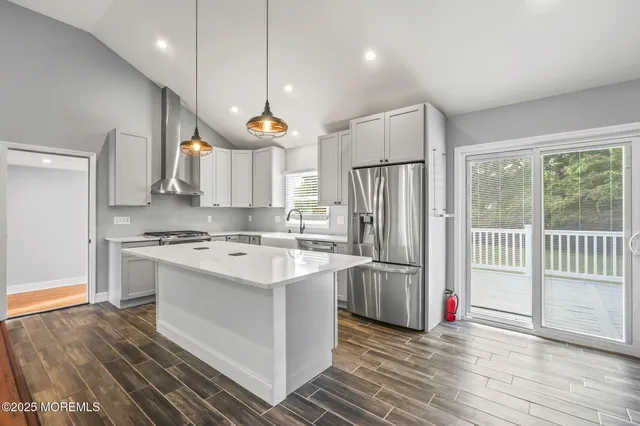 a large kitchen with kitchen island a sink stainless steel appliances and cabinets