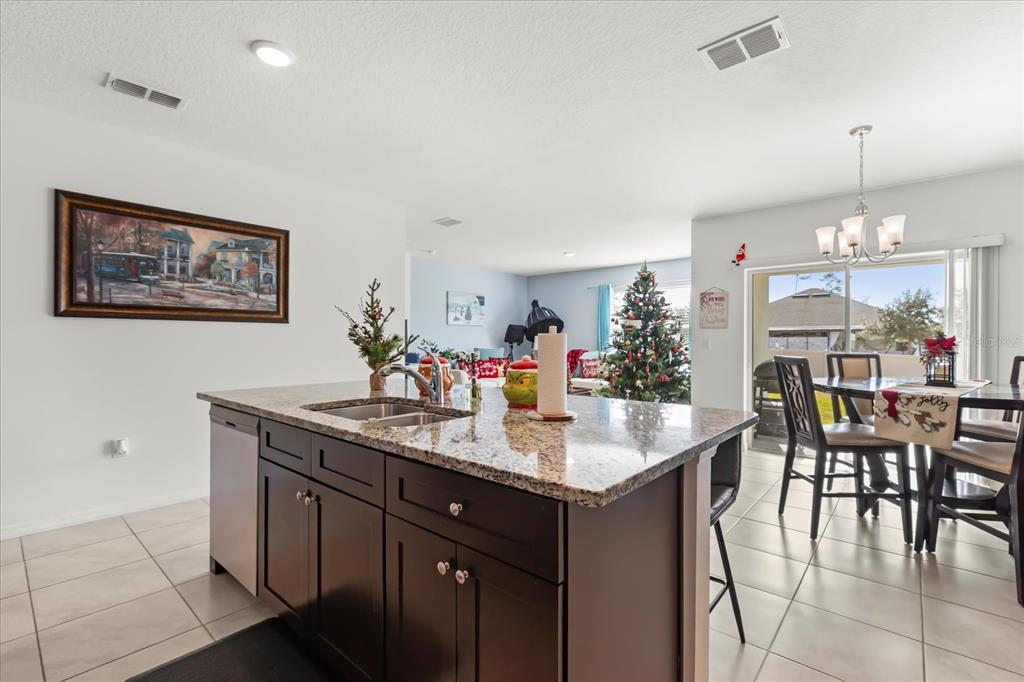 201 Wood Hollow Road DeLand, FL 32724 - Photo 11 of 32 a kitchen with kitchen island granite countertop a table and chairs in it