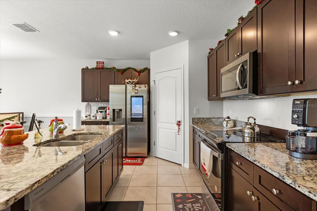 201 Wood Hollow Road DeLand, FL 32724 - Photo 12 of 32 a kitchen with granite countertop stainless steel appliances a sink stove top oven and cabinets