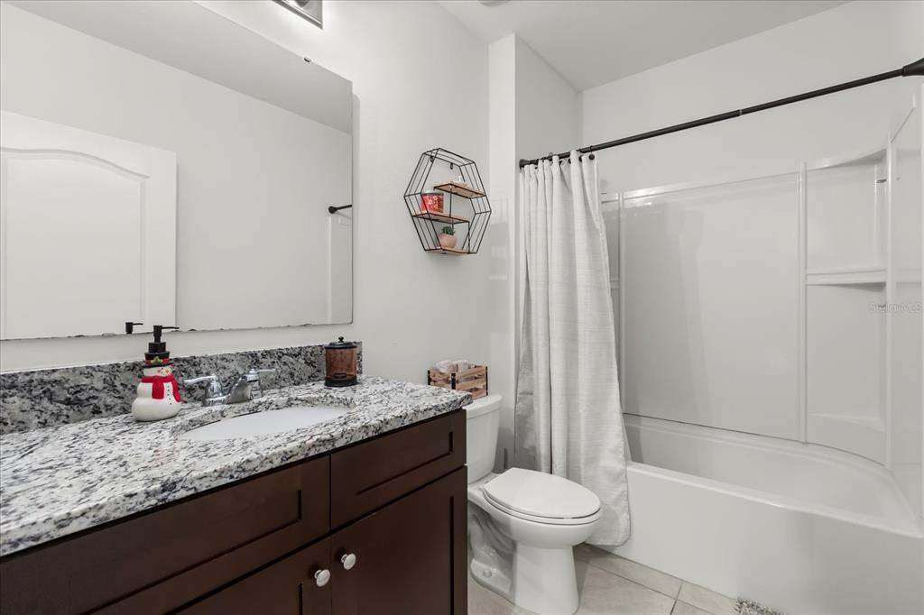 201 Wood Hollow Road DeLand, FL 32724 - Photo 16 of 32 a bathroom with a granite countertop sink toilet and shower