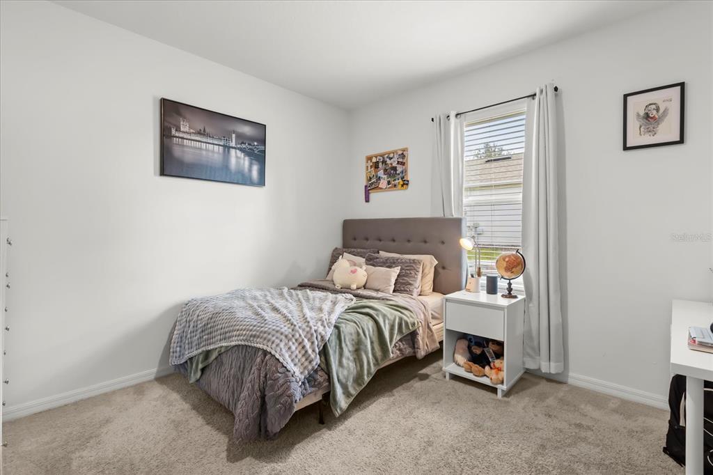 201 Wood Hollow Road DeLand, FL 32724 - Photo 19 of 32 a bedroom with a bed and a wall painting