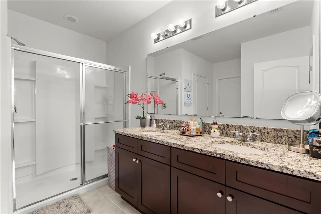 201 Wood Hollow Road DeLand, FL 32724 - Photo 26 of 32 a bathroom with a granite countertop double vanity sink mirror and shower