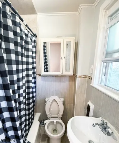 a bathroom with a sink a toilet and shower curtain