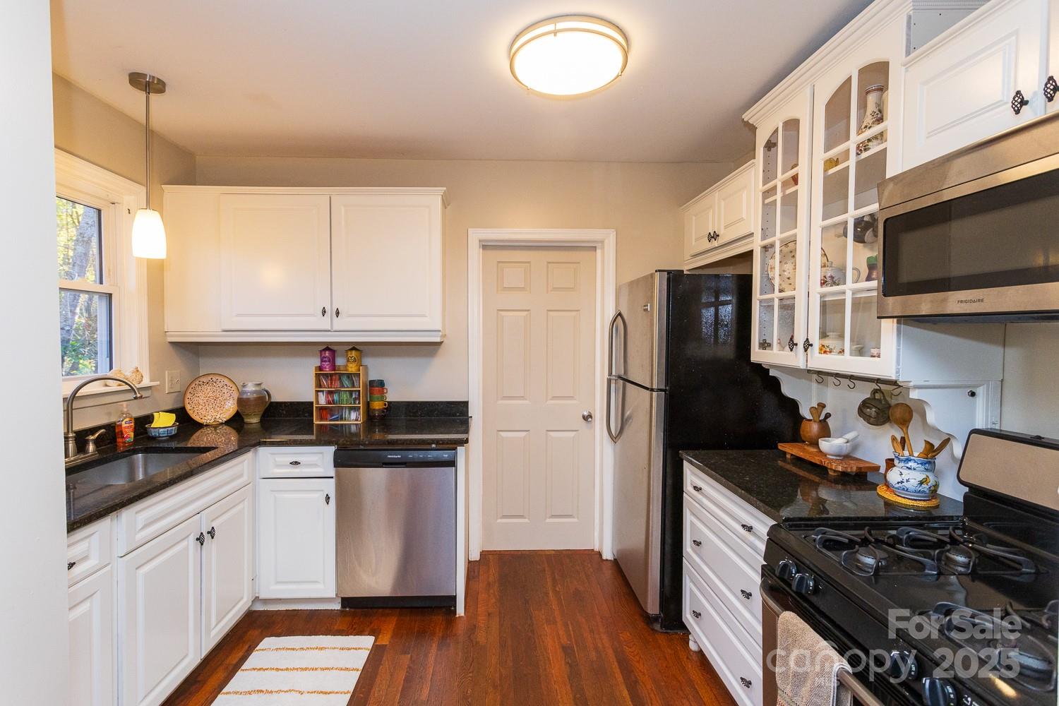87 Pershing Road Asheville, NC 28805 - Photo 11 of 48 a kitchen with stainless steel appliances a stove a sink a refrigerator and cabinets