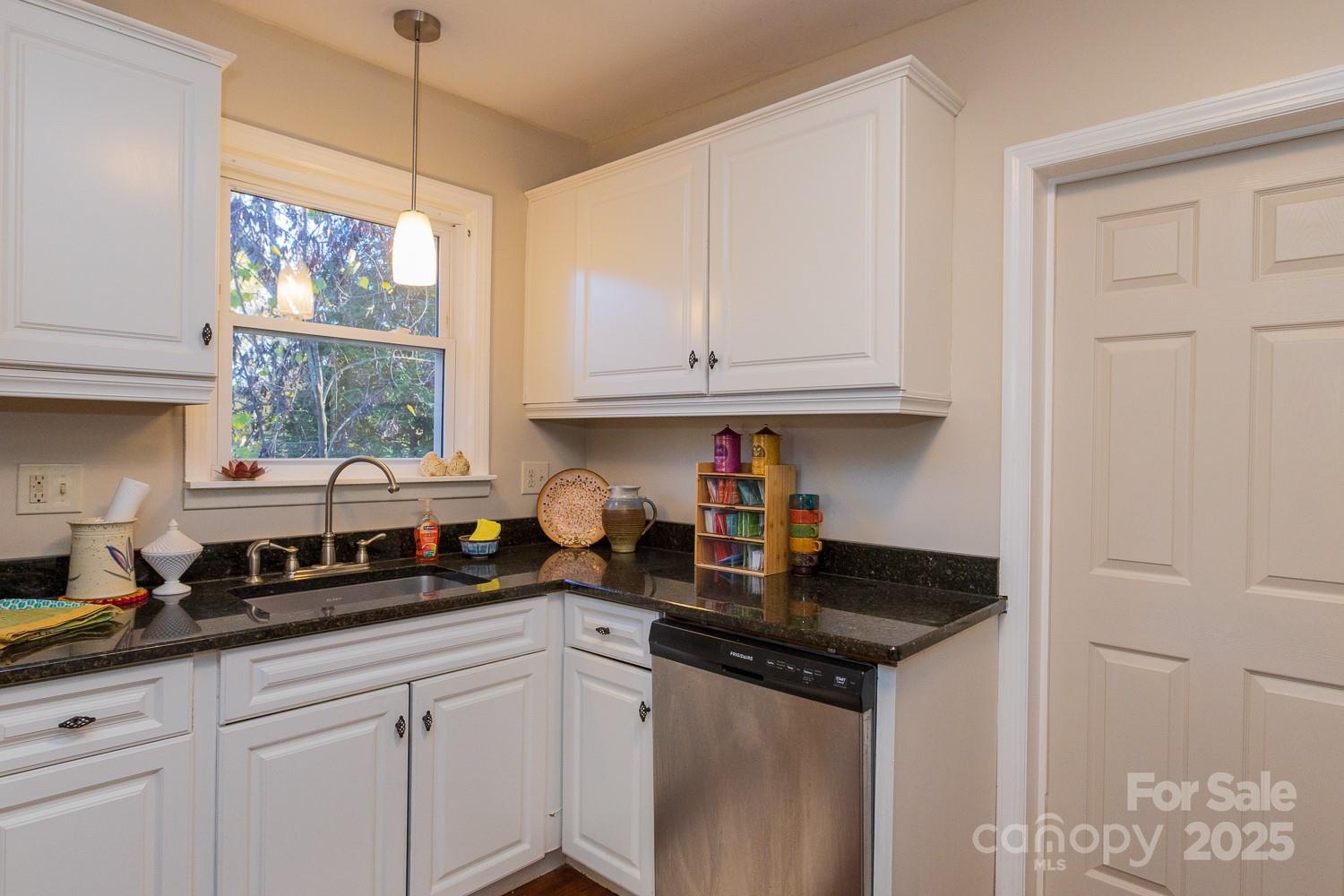 87 Pershing Road Asheville, NC 28805 - Photo 13 of 48 a kitchen with stainless steel appliances granite countertop a sink a stove and cabinets
