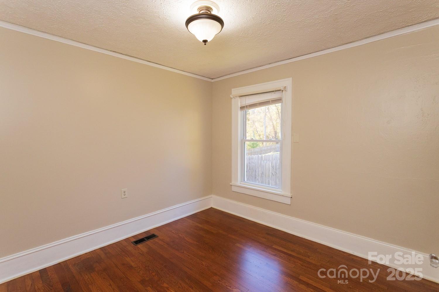 87 Pershing Road Asheville, NC 28805 - Photo 20 of 48 an empty room with wooden floor and windows