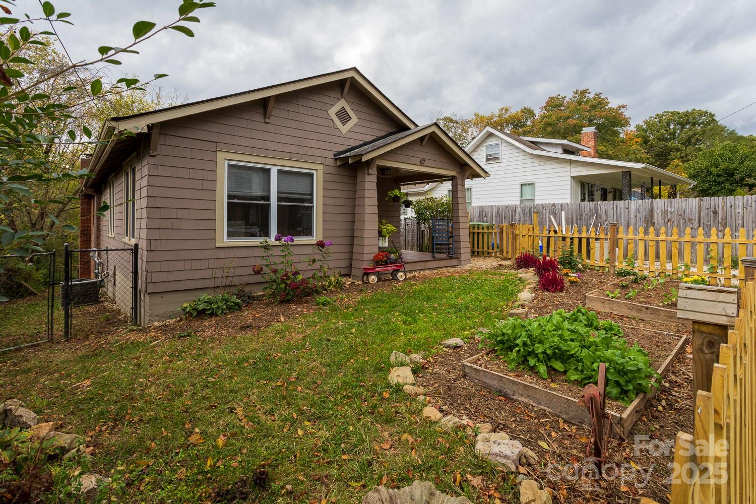 87 Pershing Road Asheville, NC 28805 - Photo 3 of 48 a front view of house with small garden and outdoor seating
